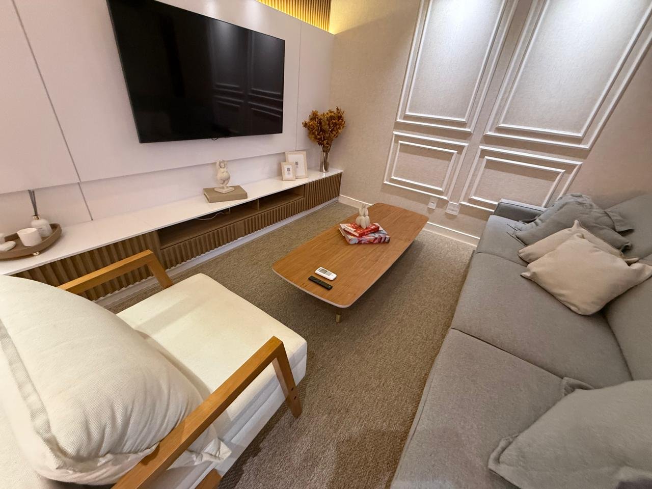 Living com painel de televisão e decoração contemporânea